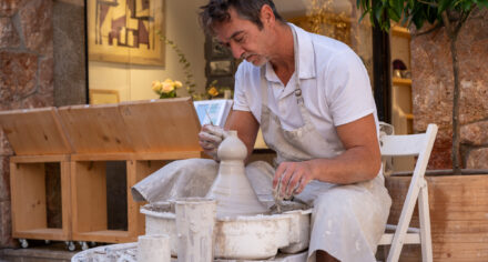 Teo Méndez Martínez throwing clay on a potter's wheel outside Fandango Pollença
